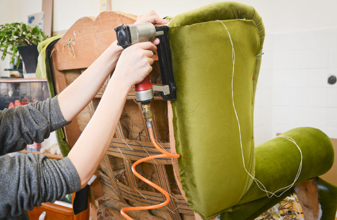 a professional restoring furniture using professional equipment