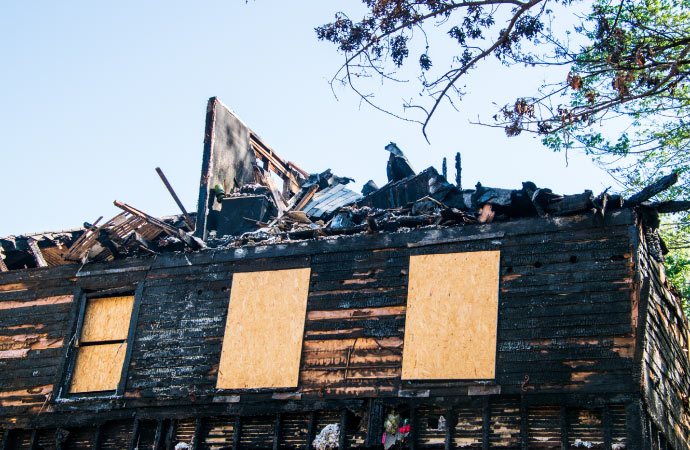 a boarded up burnt house