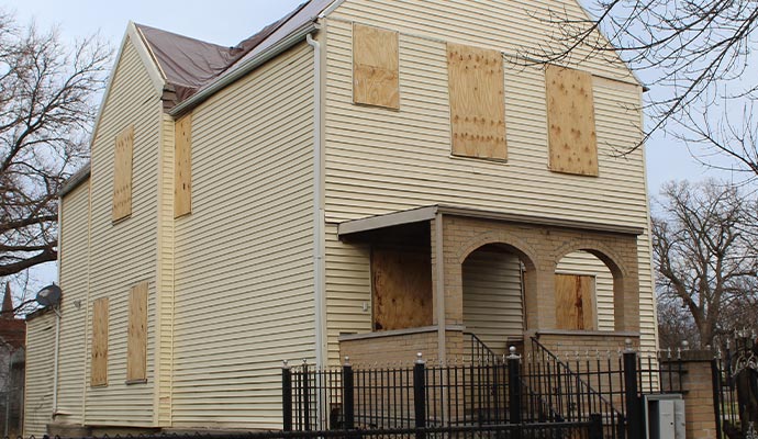 Boarded-up windows and doors on a house