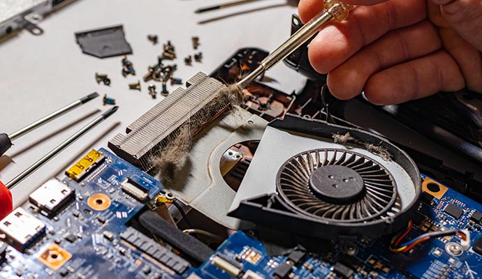 Person cleaning the internal components of a Laptop