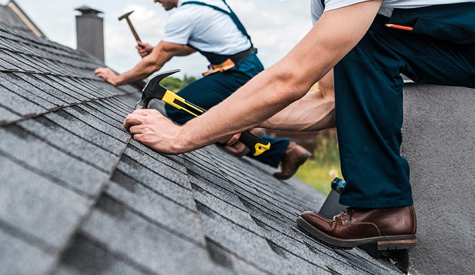 Professional installing roof shingles and performing roof installation tasks