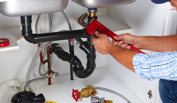 A professional technician is repairing a kitchen sink